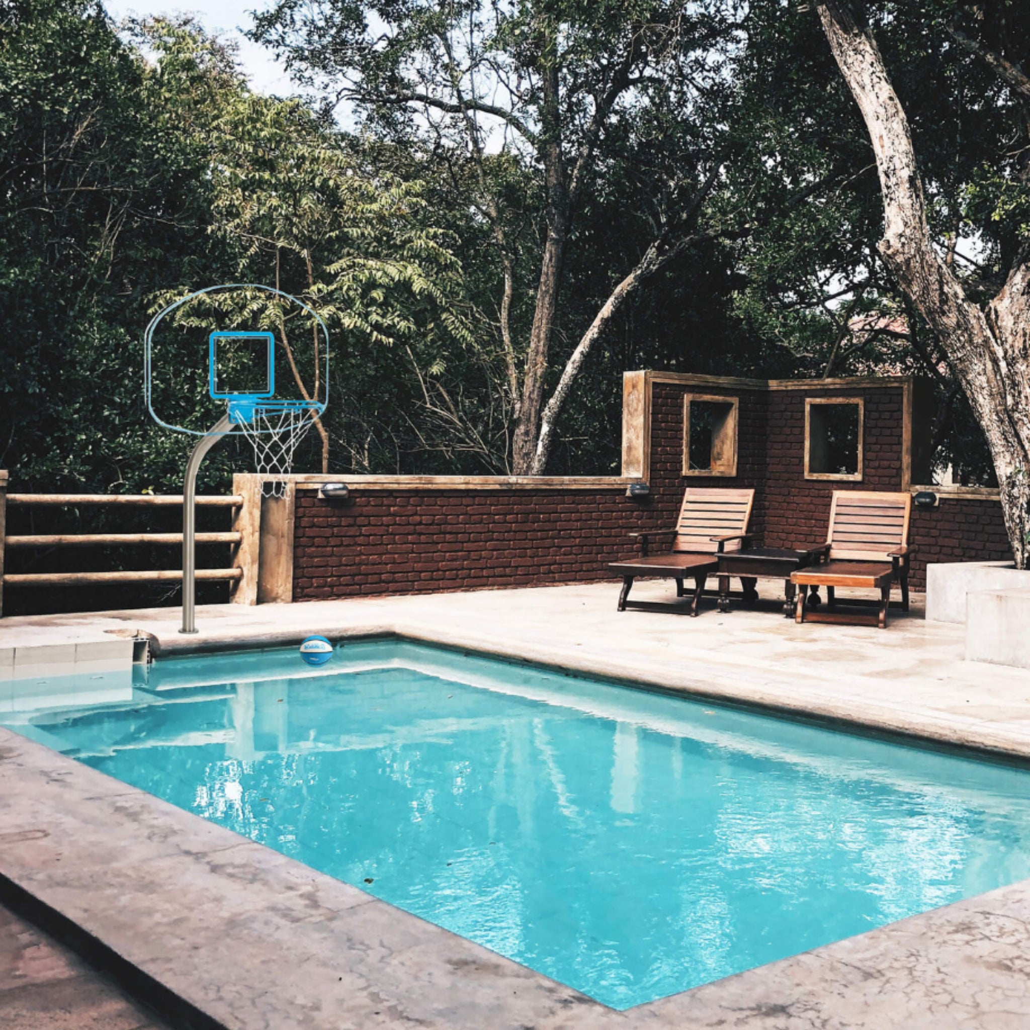 Clear Hoop pool basketball hoop showing stainless steel post and vinyl-coated rim at residential pool