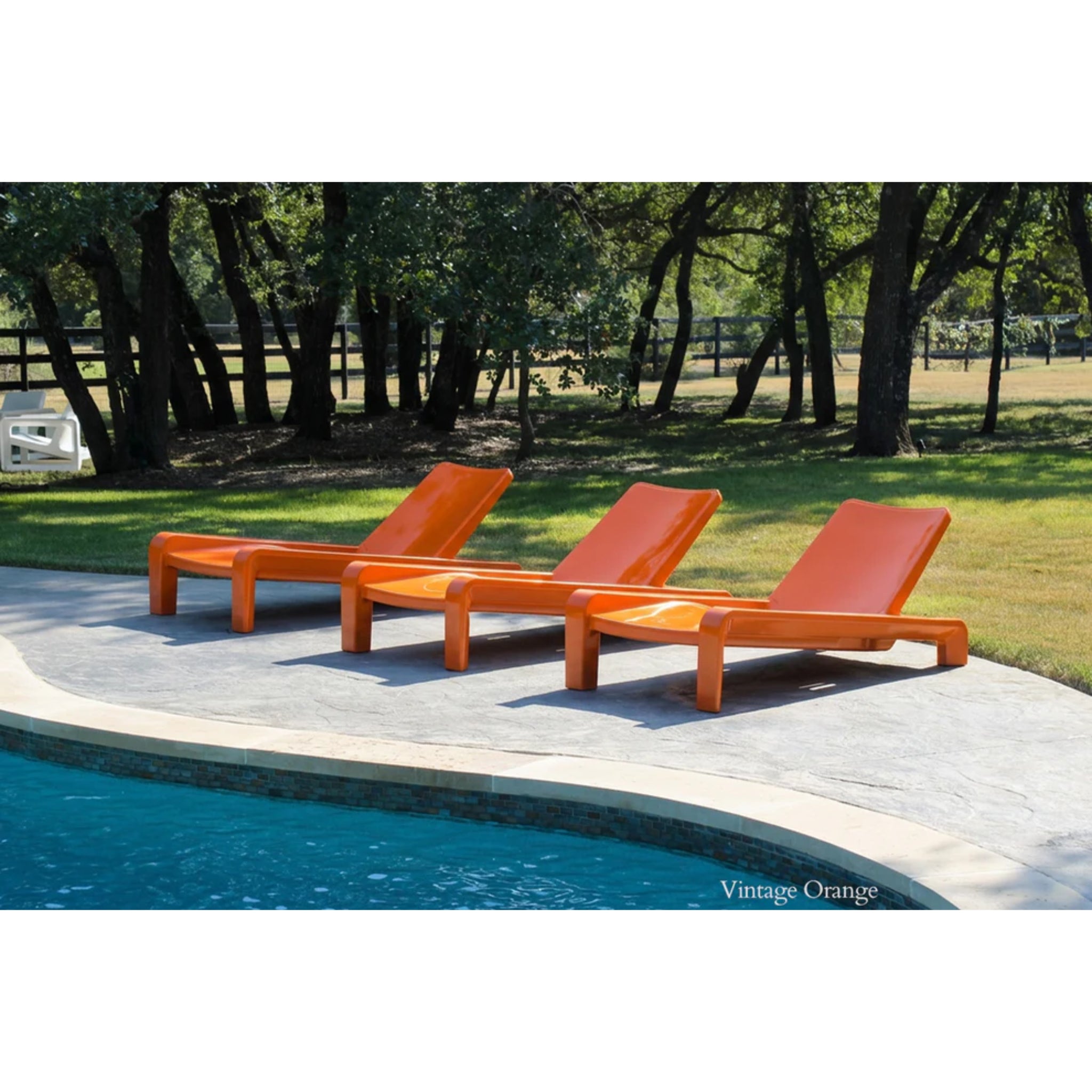 Luxury orange in-pool chaise lounge chairs positioned on a baja shelf beside a resort-style swimming pool