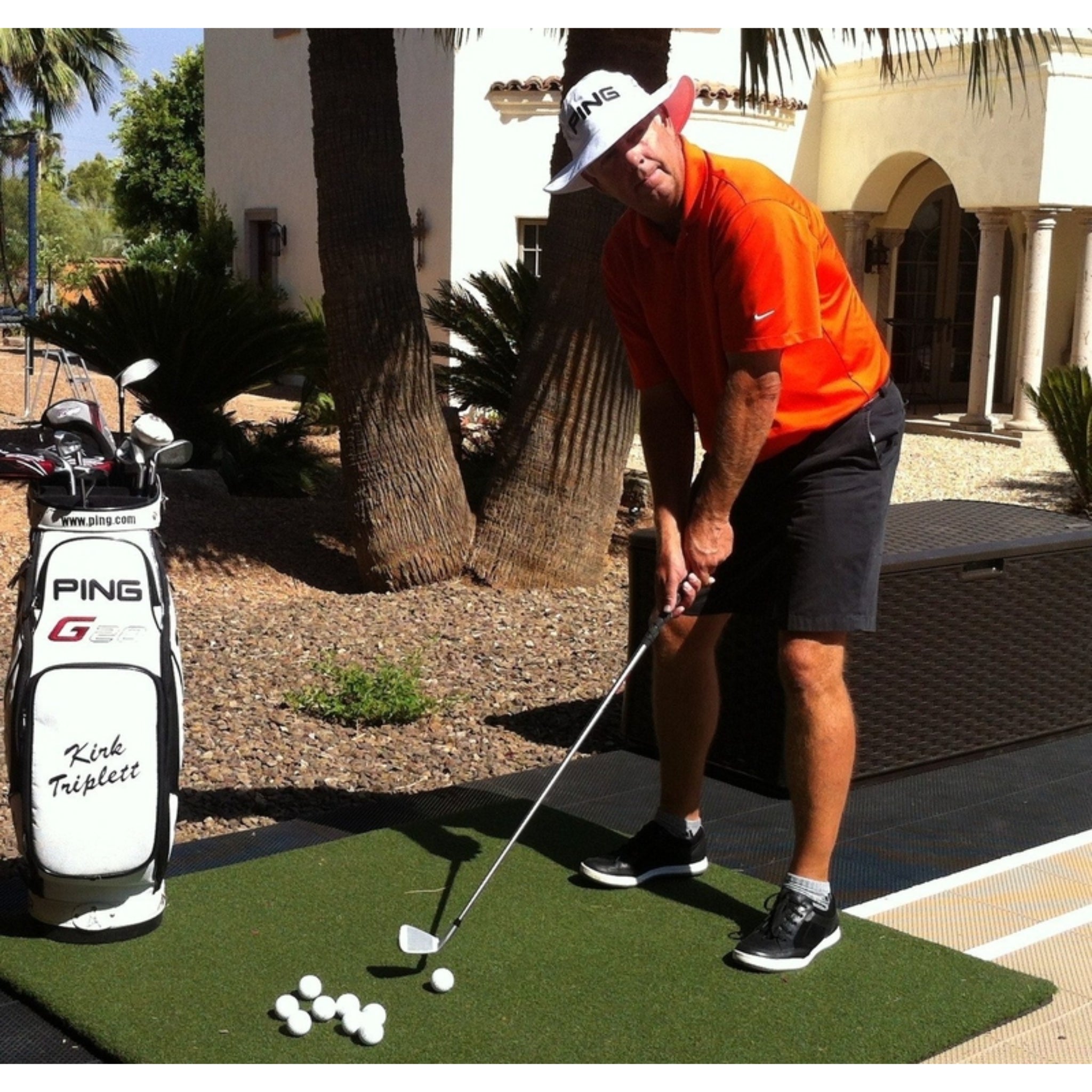 Golfer practicing iron shots on the Country Club Elite Golf Hitting Mat by Real Feel with true-turf feedback and commercial-grade construction for high-traffic use