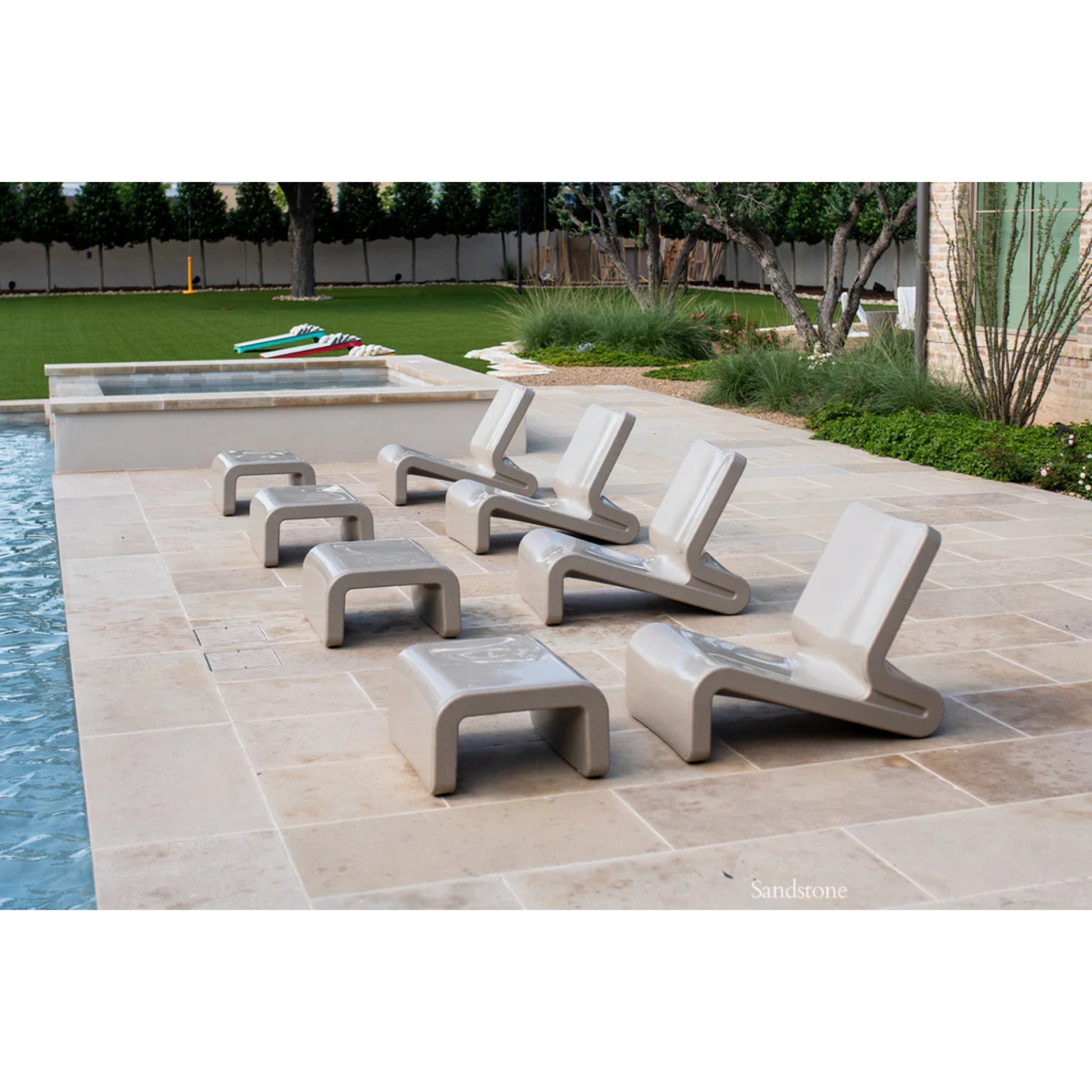 Tupelo Line Ottoman in sandstone color beside luxury in-pool lounge furniture on a resort-style patio deck