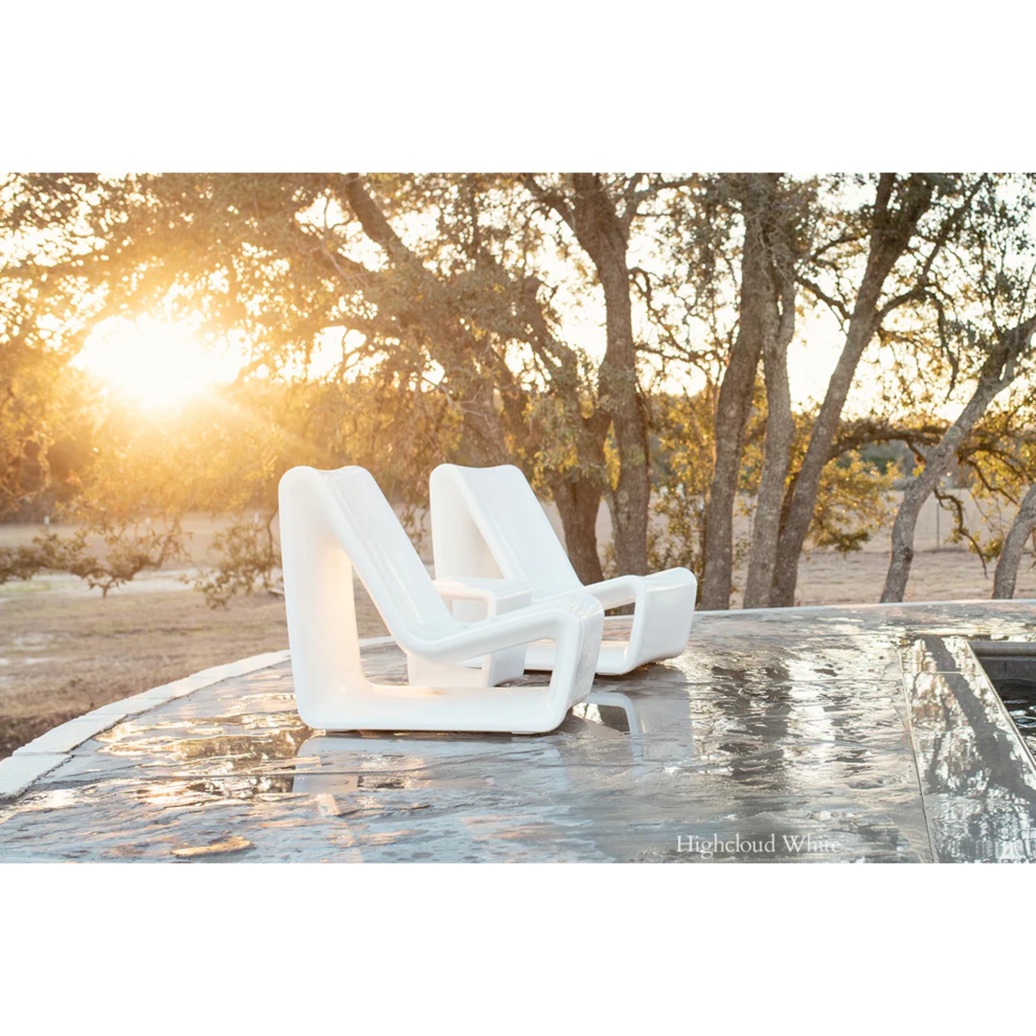 Modern white outdoor lounge chair designed for in-pool use on a residential baja ledge