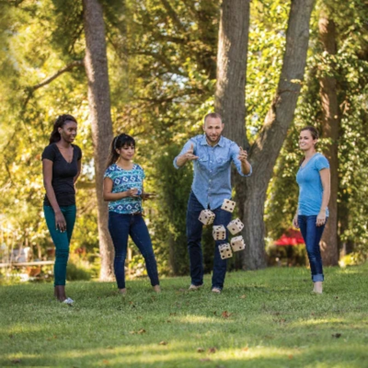 Group of friends playing giant dice game in backyard