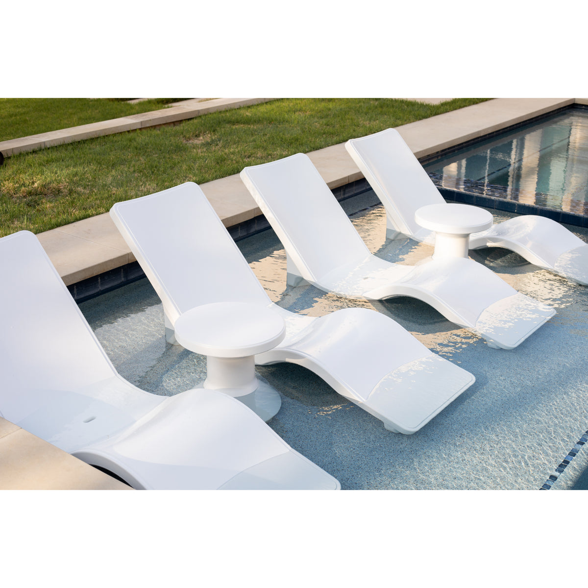 Angled overhead view of white pool shelf lounge chairs on an in-pool sun shelf, with two round pedestal side tables spaced between them SKU 8902-700 in Highcloud White.
