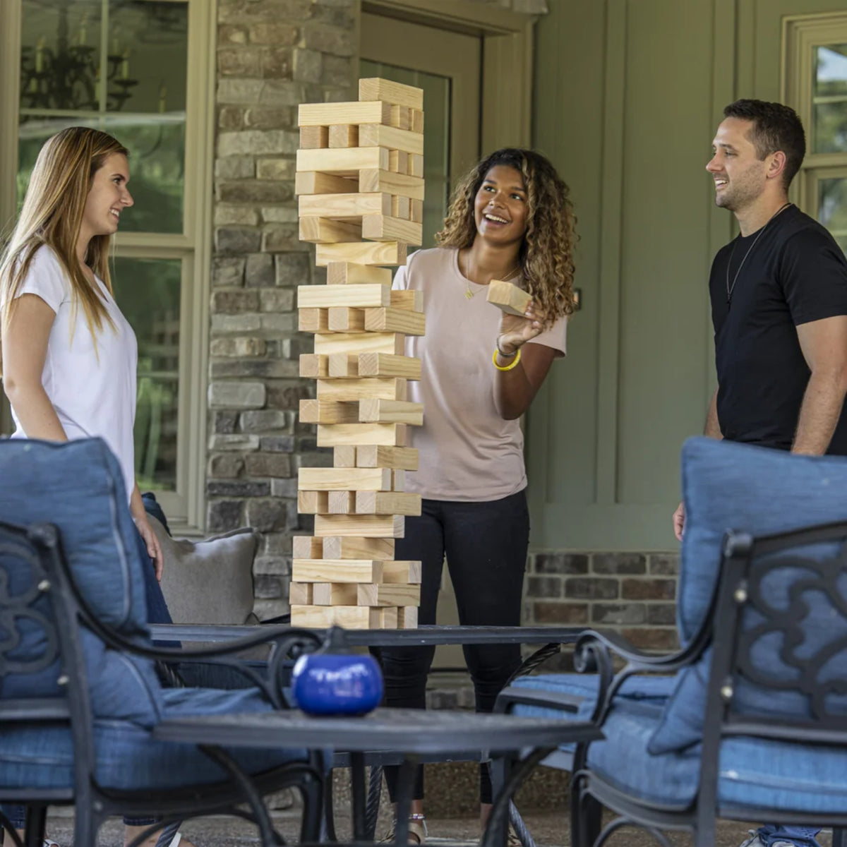 Guests playing Triumph Giant Wooden Tumble Tower at an outdoor gathering