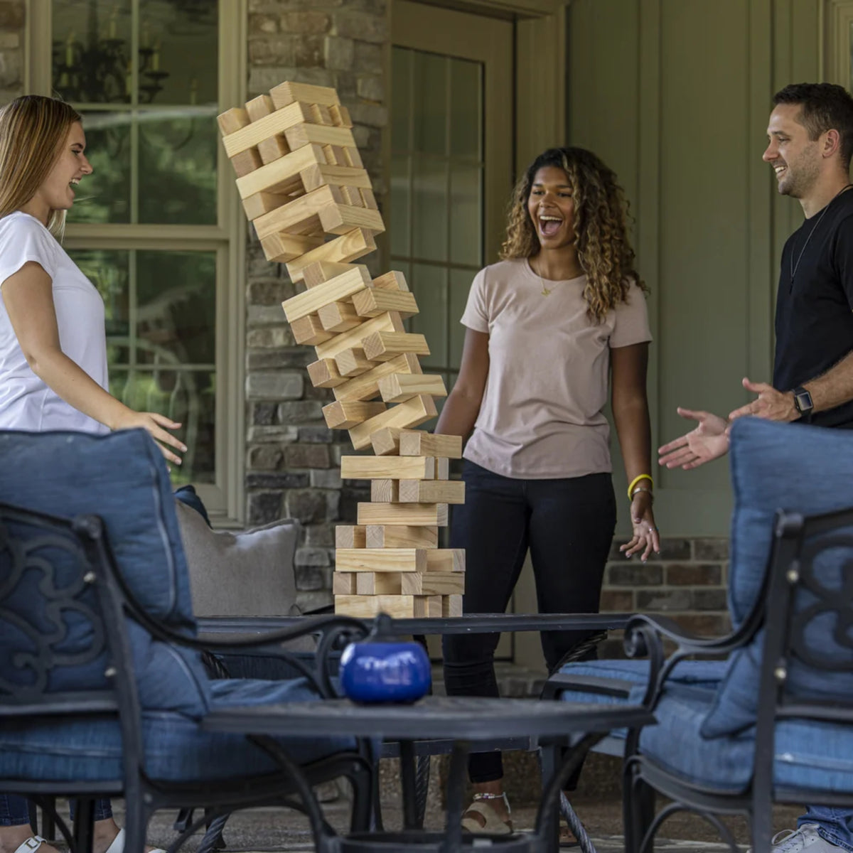 Friends enjoying the Triumph giant stacking game during a backyard party