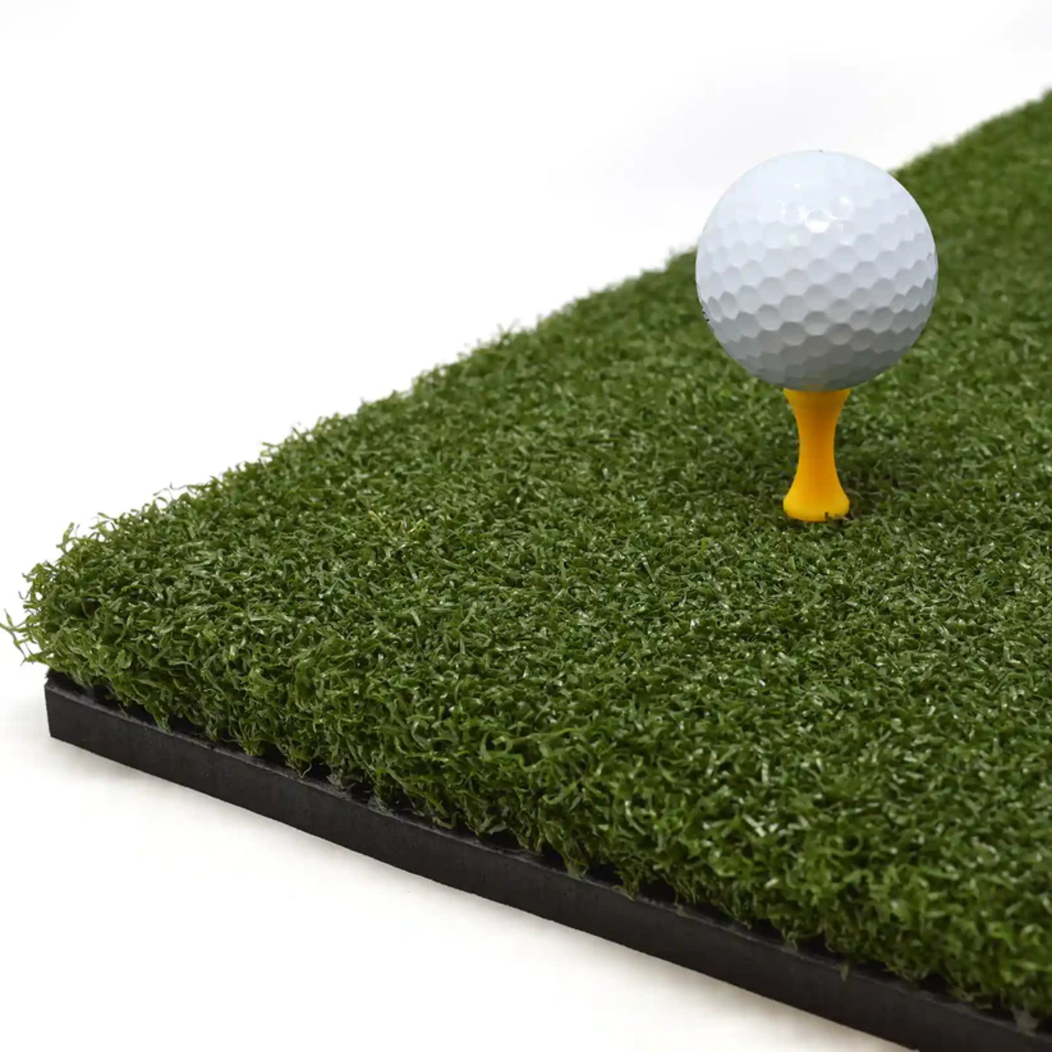 Golf ball on real tee on SimSpace Tee Turf Mat showing thick turf surface for realistic golf practice
