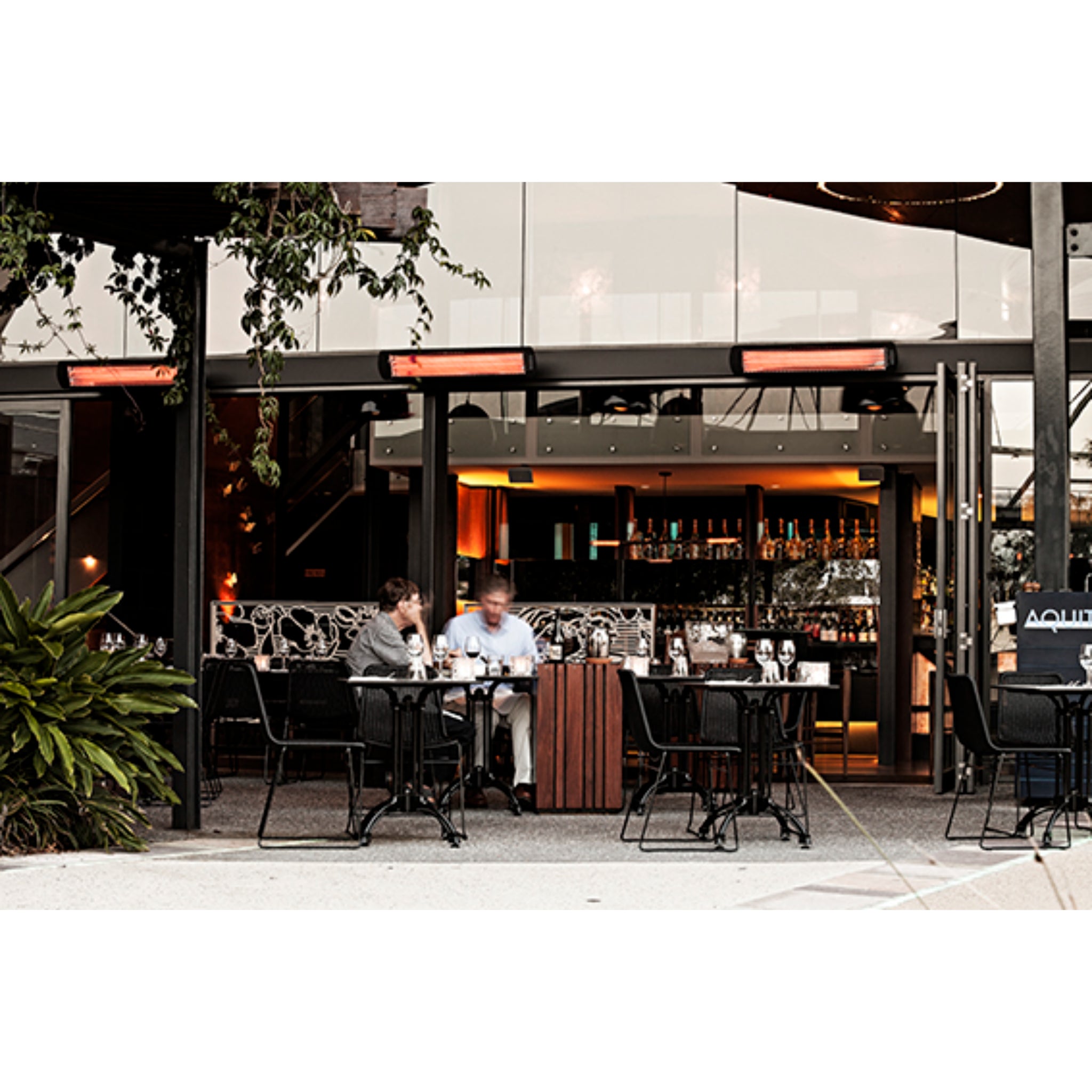 Wall mounted Bromic Tungsten electric infrared patio heater in black on restaurant patio
