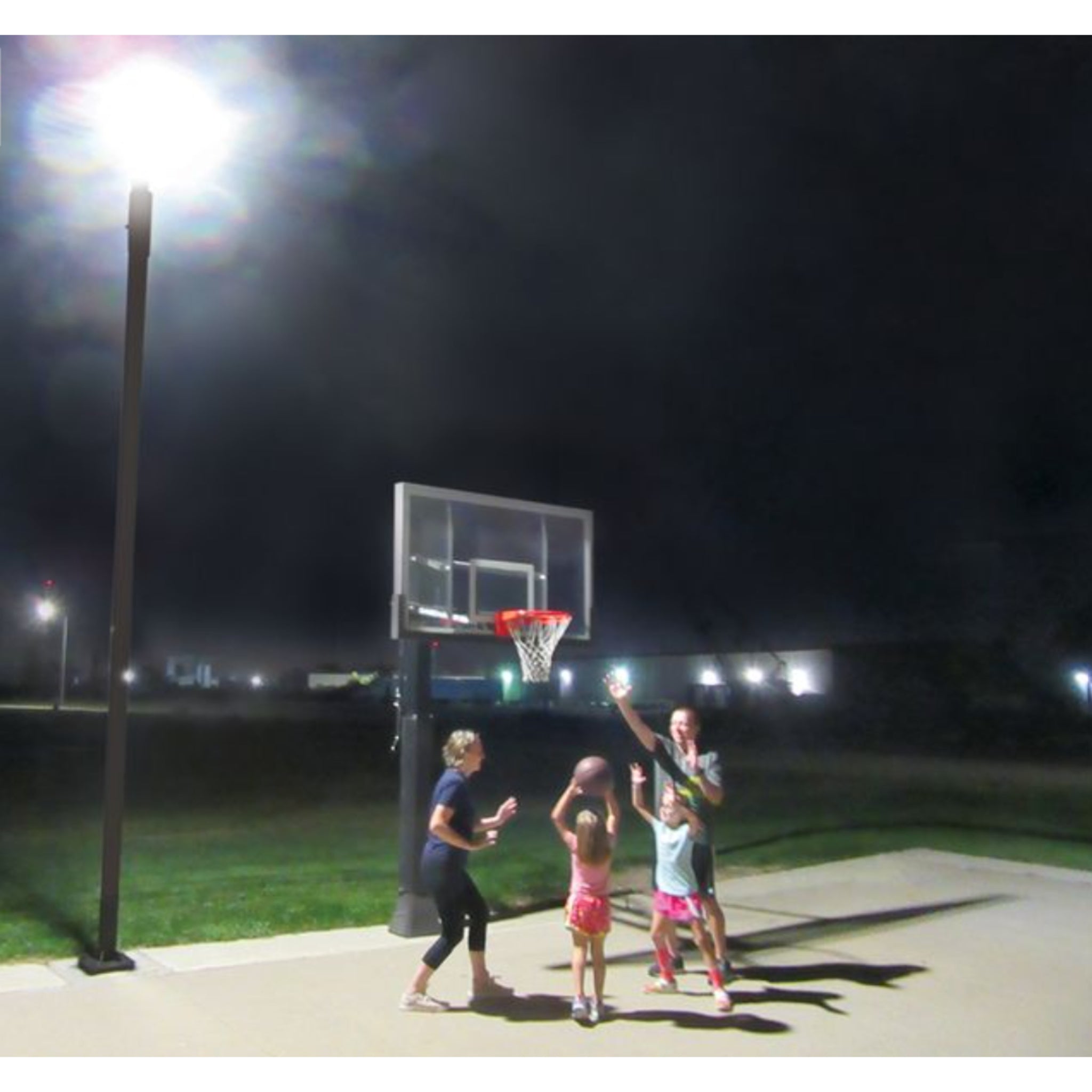 Outdoor basketball court illuminated by Court Vision solar powered court light