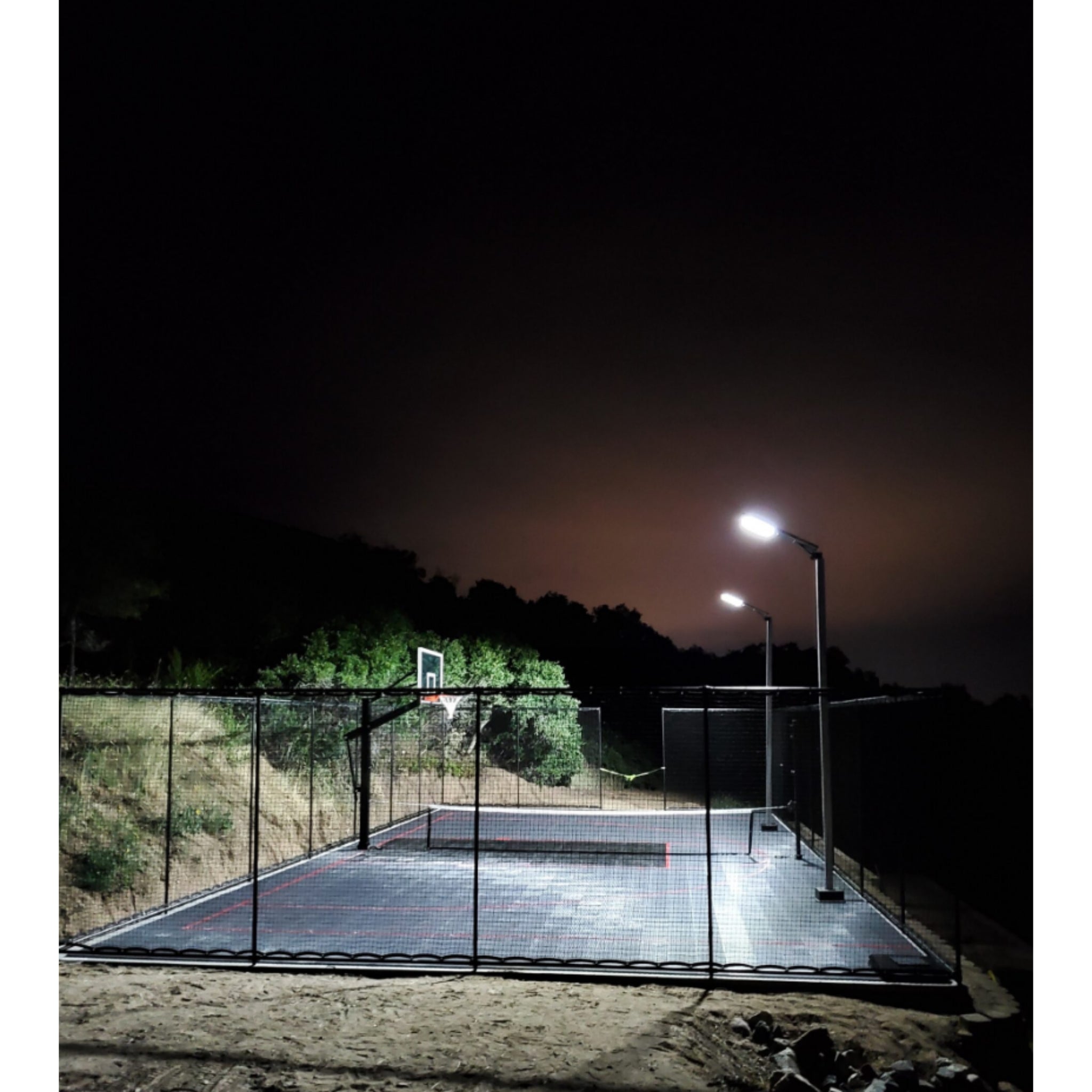Outdoor basketball court illuminated by Dominator solar light pole at night