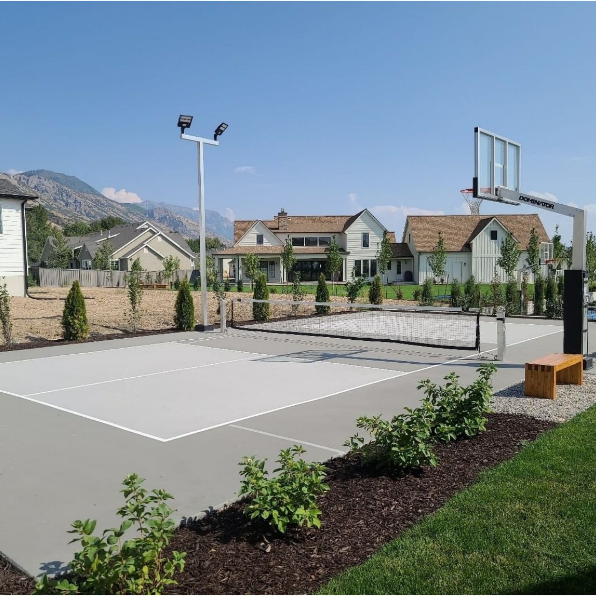 Outdoor basketball court illuminated by Dominator wired LED sport court lighting system