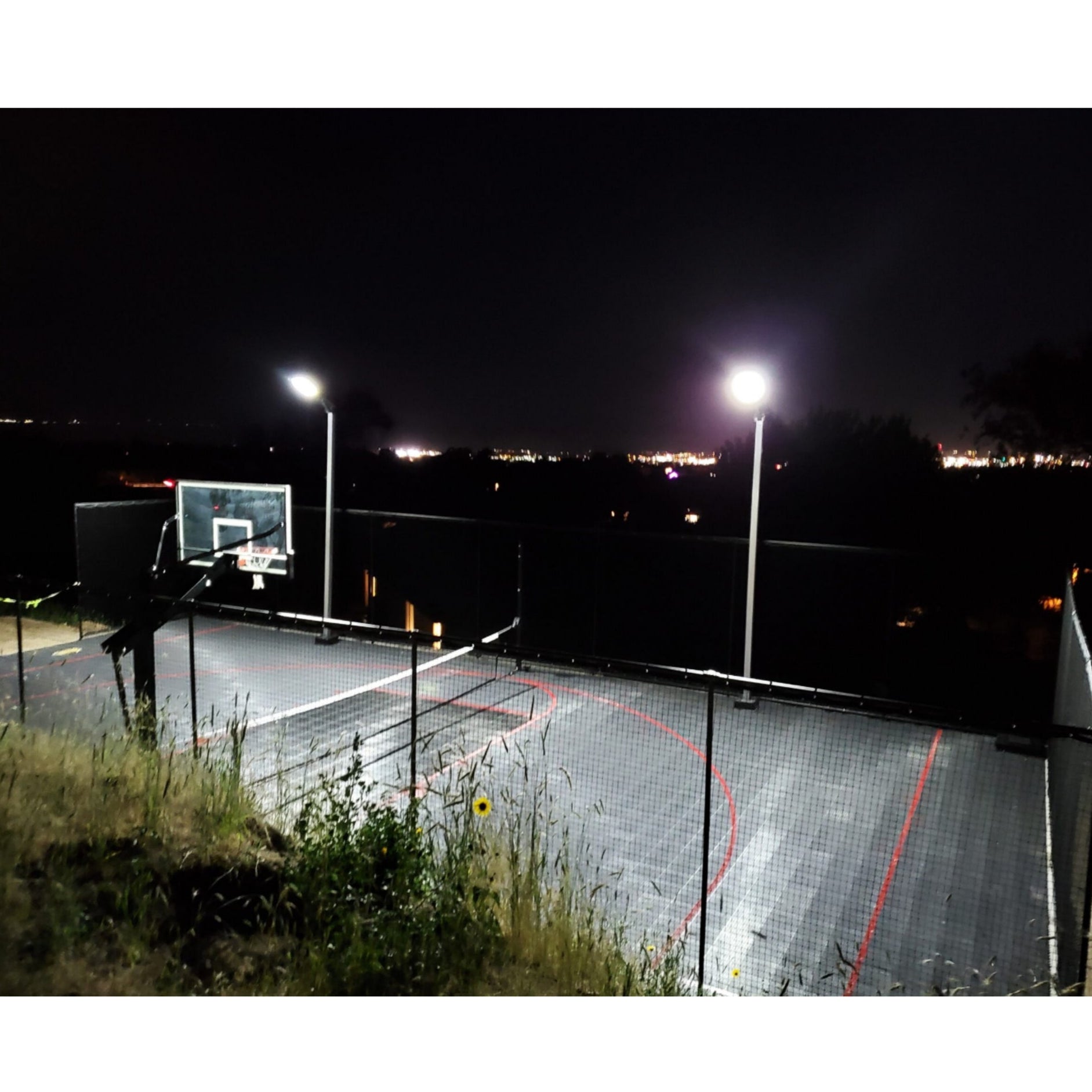 Dominator wired basketball court light pole with LED fixtures installed on outdoor court