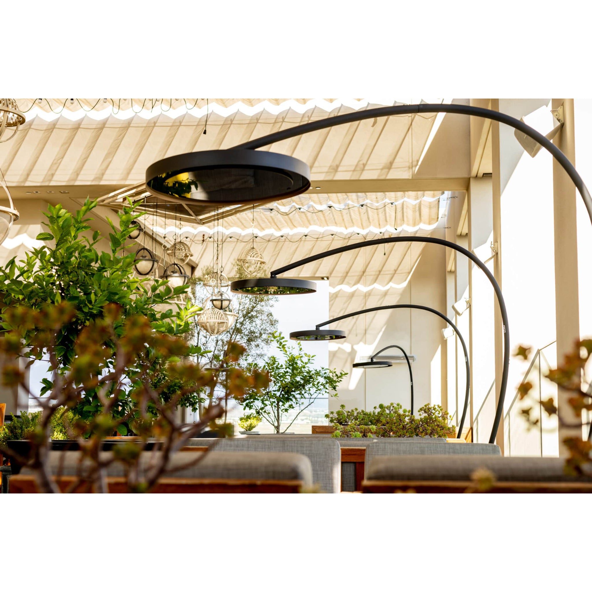 Freestanding Bromic Eclipse electric patio heater with curved pole at resort