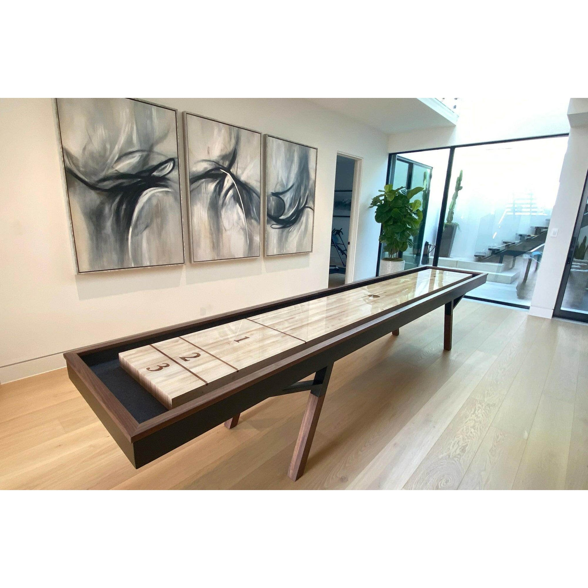 Woolsey indoor shuffleboard table in a modern living room with abstract art on the wall.