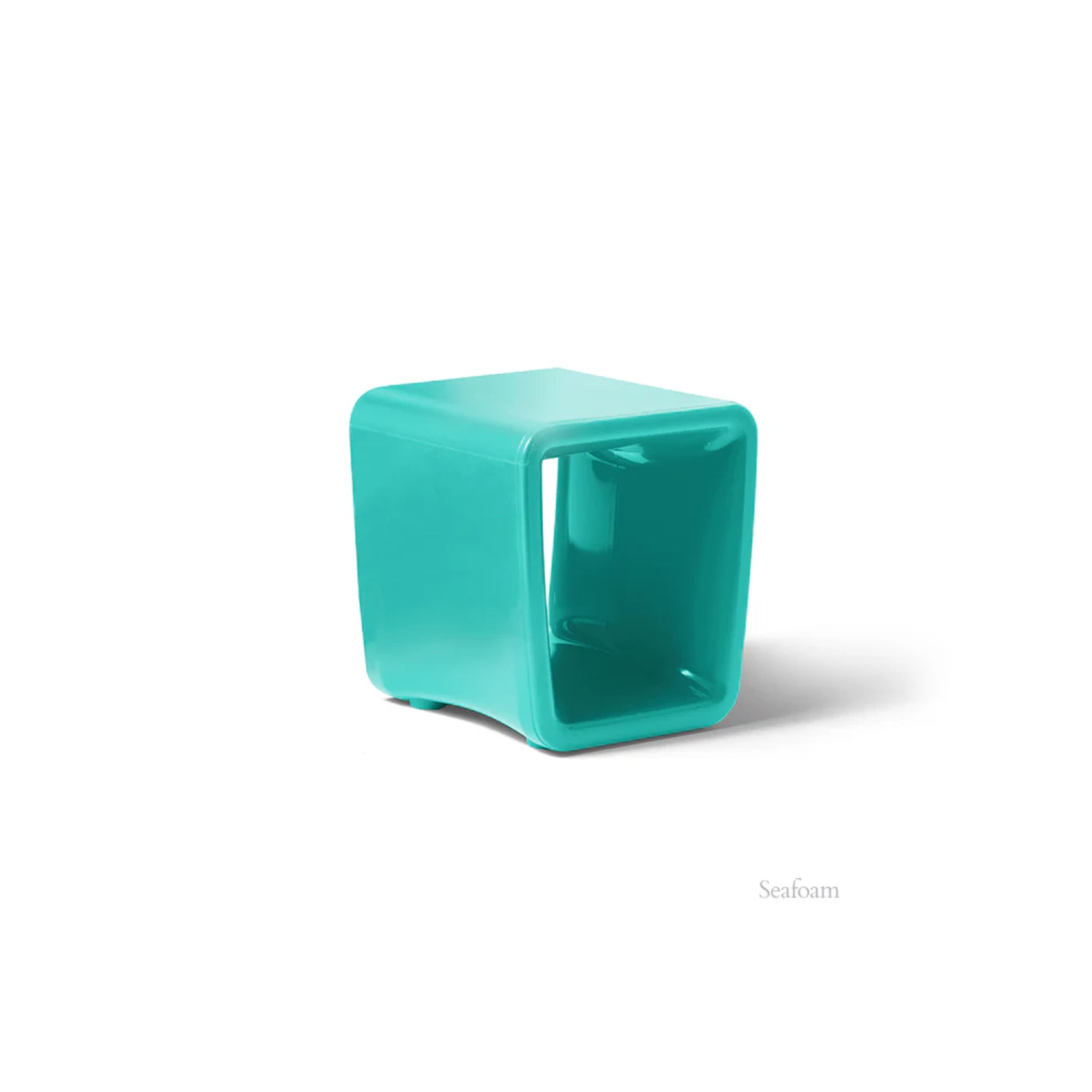 Turquoise cube-shaped side table on a white background