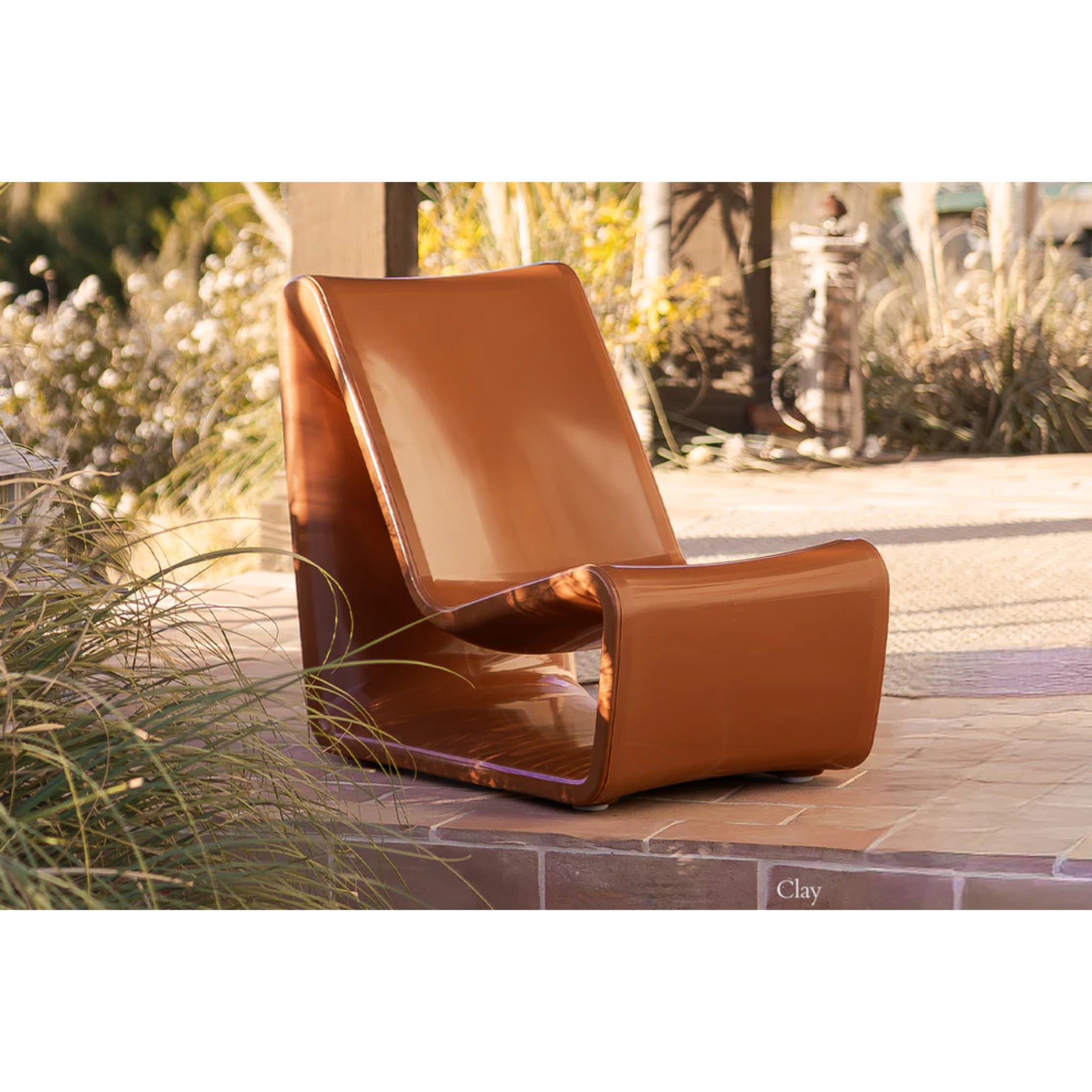 Clay-colored outdoor lounge chair creating a sophisticated poolside retreat on a baja shelf