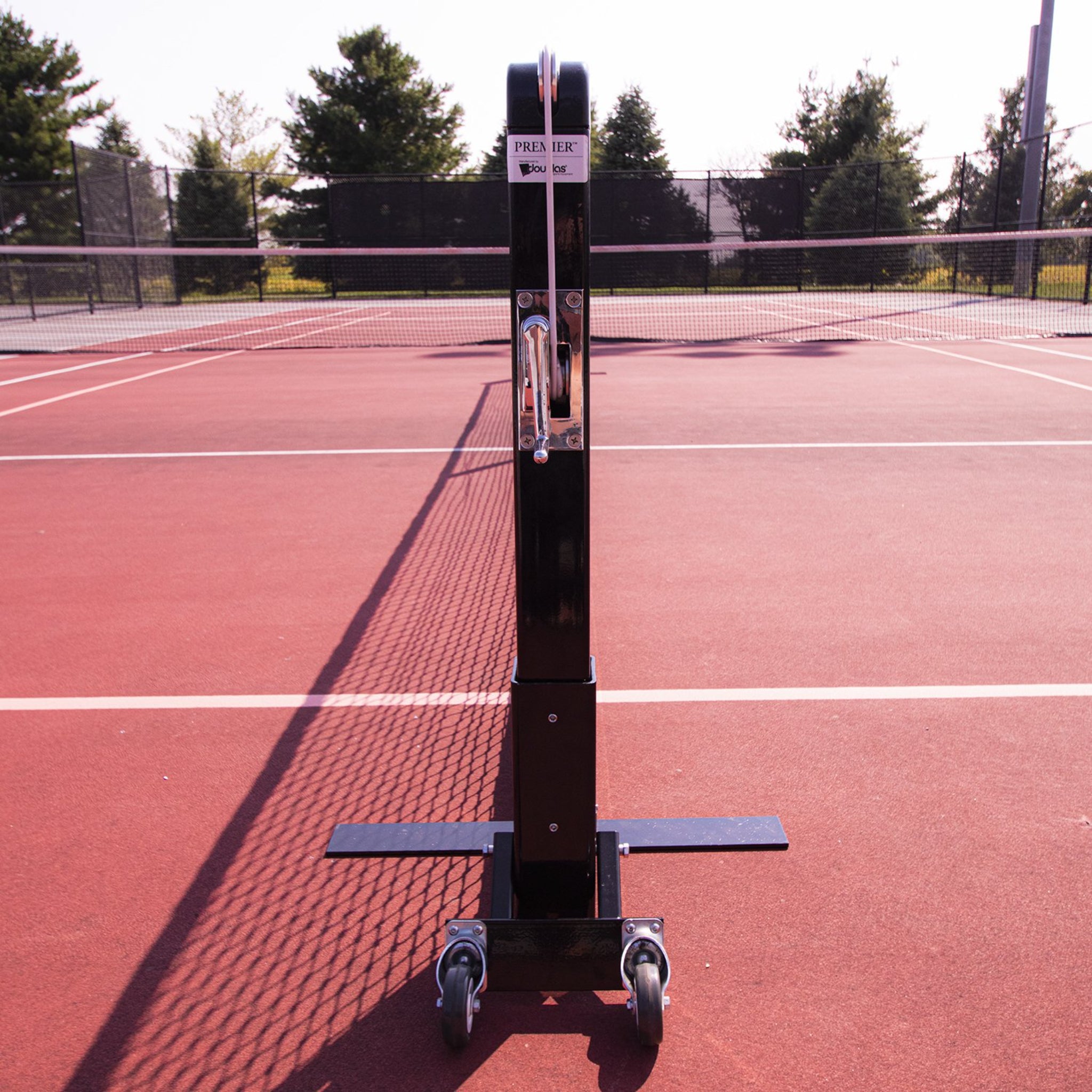 Side view of Douglas portable pickleball net system with flat stabilizer legs and transport wheels