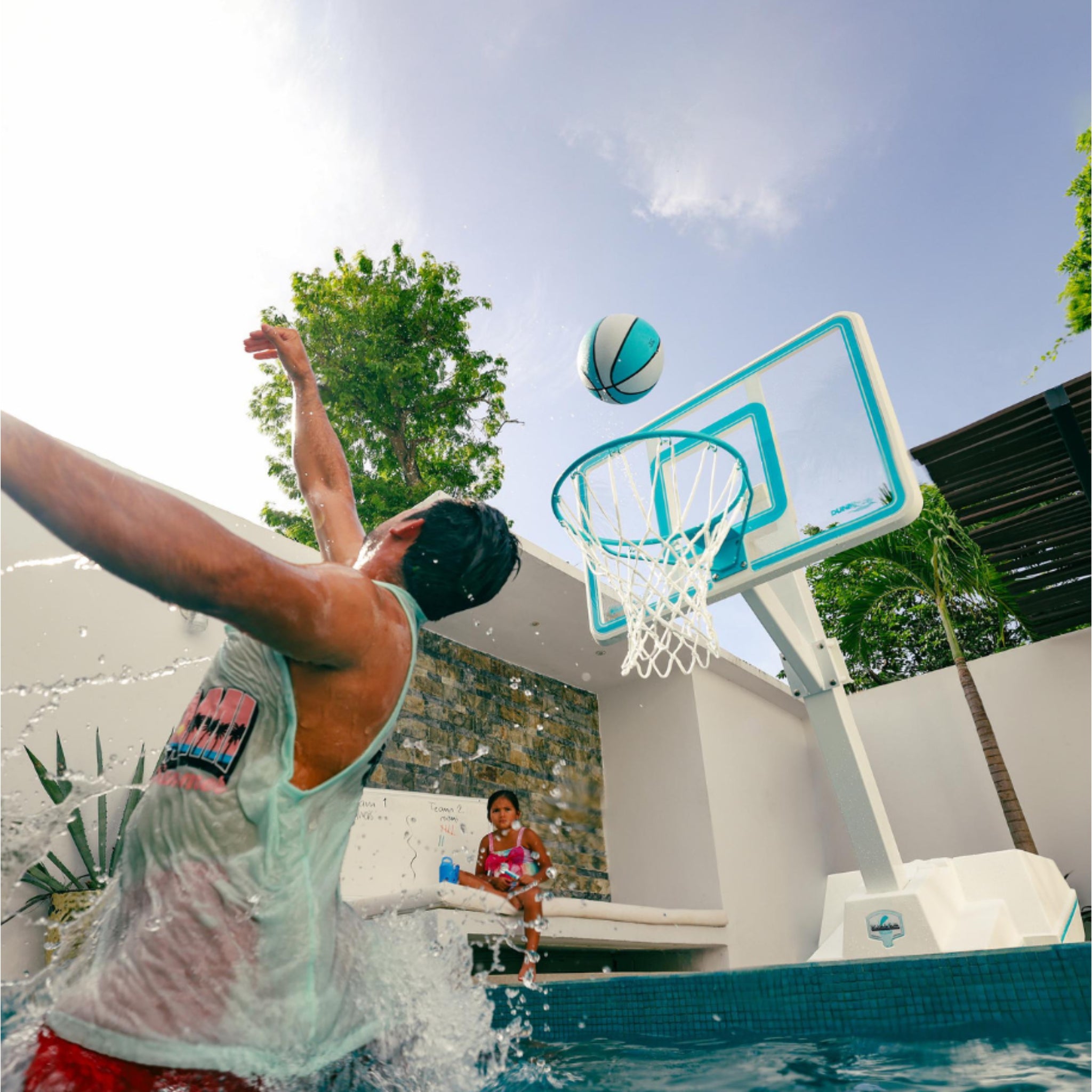 Dunn-Rite clear backboard pool basketball hoop installed at pool edge with people playing