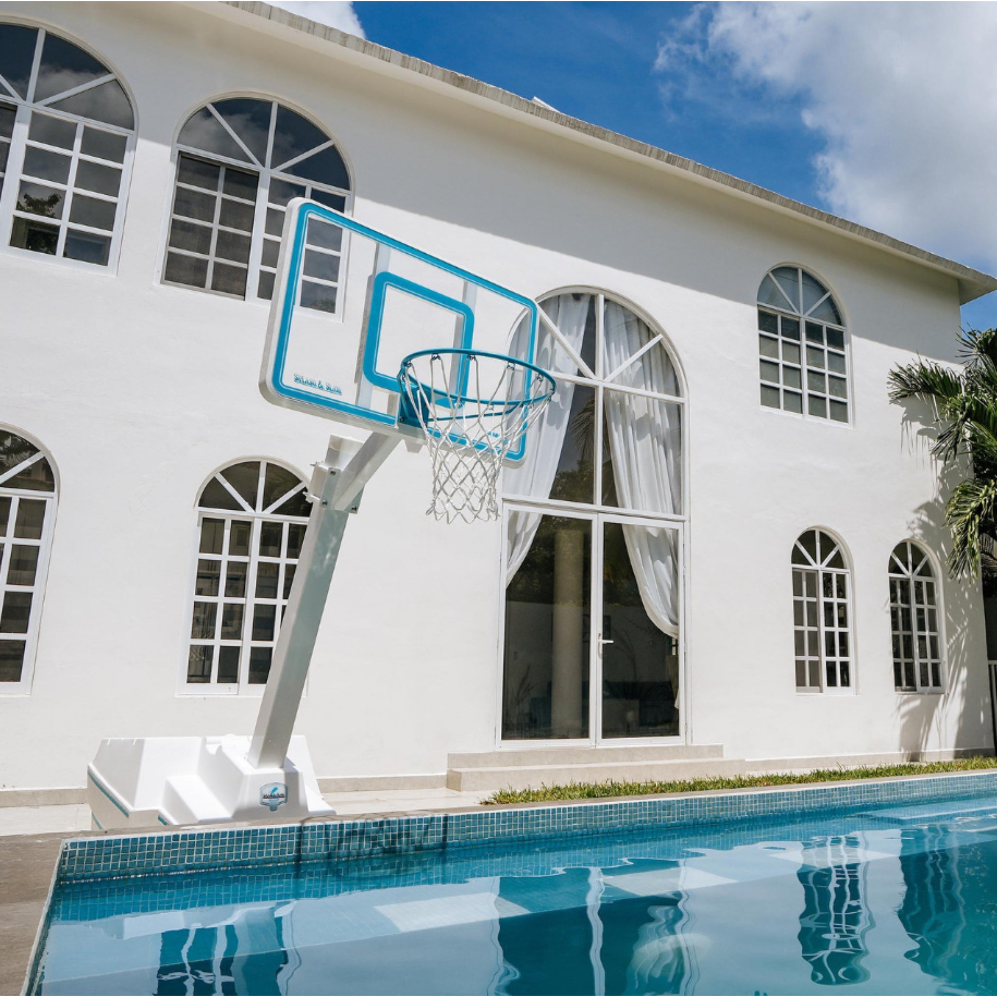 Poolside basketball hoop with clear backboard and freestanding water-filled base by Dunn-Rite