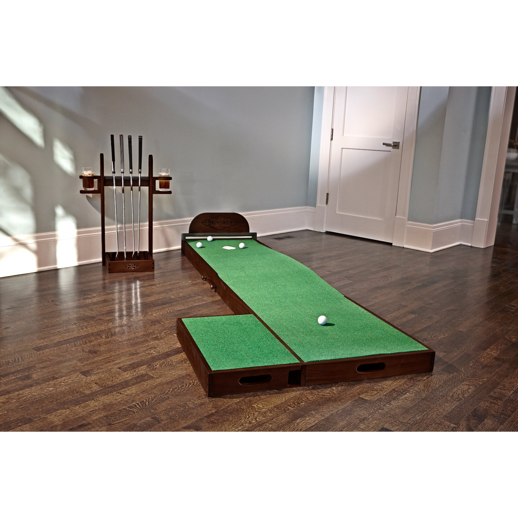 Brunswick The Ross indoor putting green in interior room with matching espresso trim putter holder.