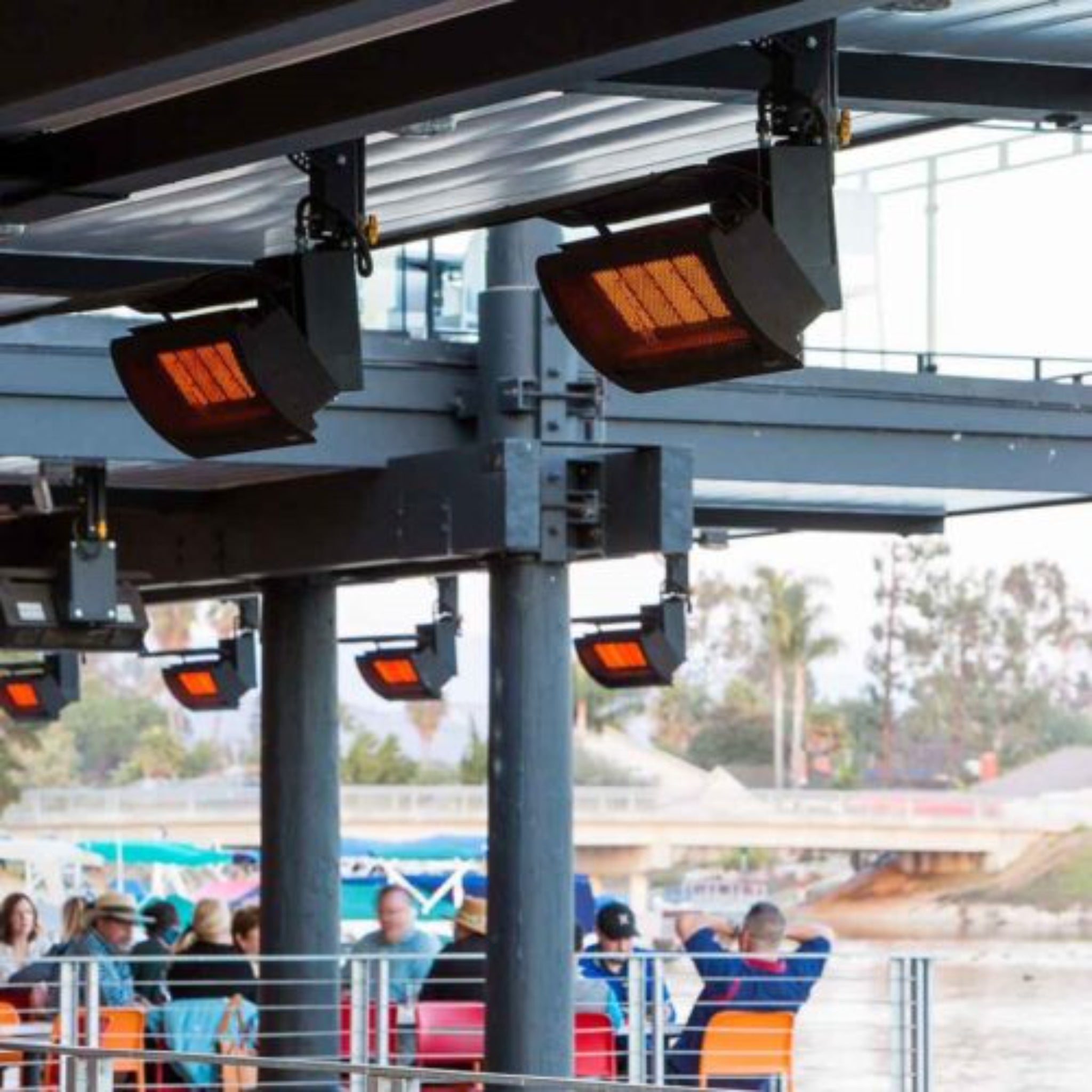 Heat deflector installed above Bromic outdoor gas heater for reduced clearance