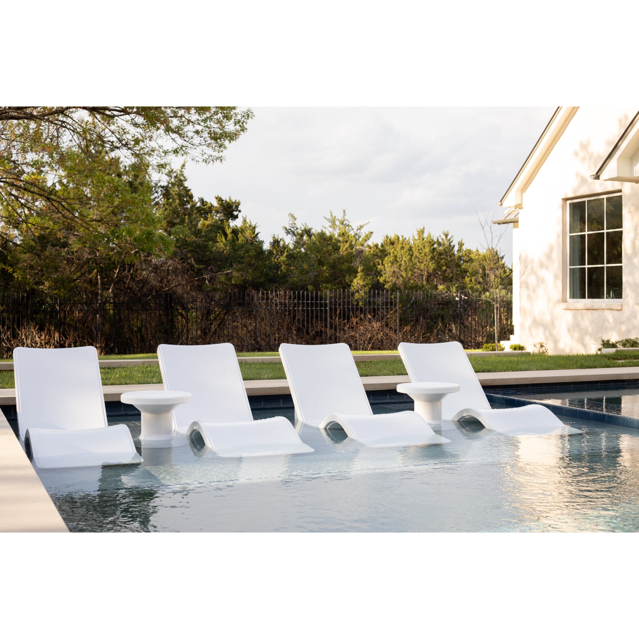 White in pool lounge chair positioned on sun shelf with shallow water coverage
