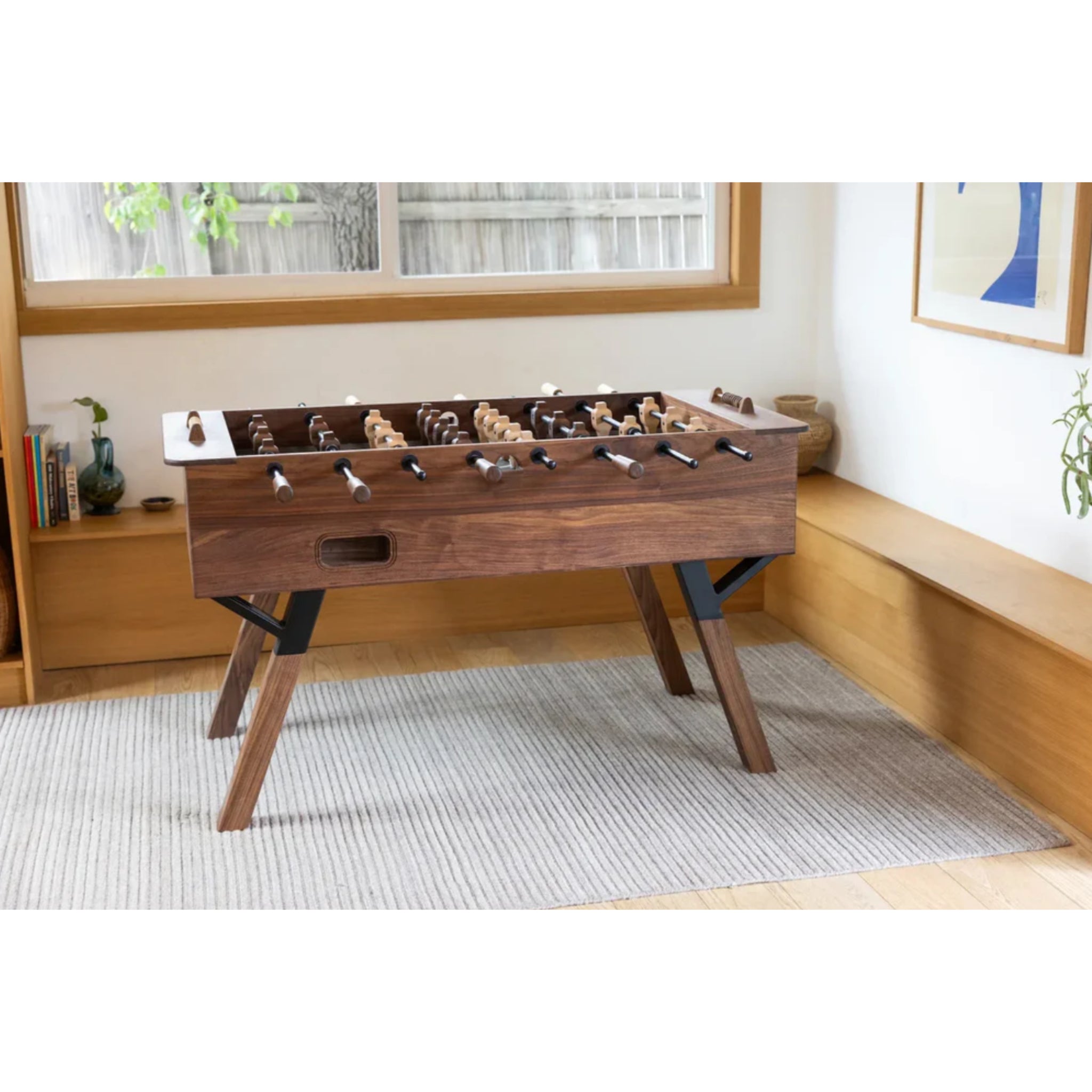Modern walnut foosball table in contemporary interior setting